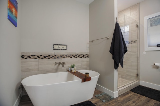 bathroom with hardwood / wood-style floors, tile walls, and shower with separate bathtub