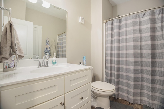 bathroom with vanity, toilet, and hardwood / wood-style floors