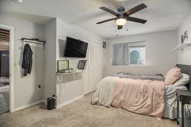 carpeted bedroom featuring a closet, ceiling fan, and a textured ceiling