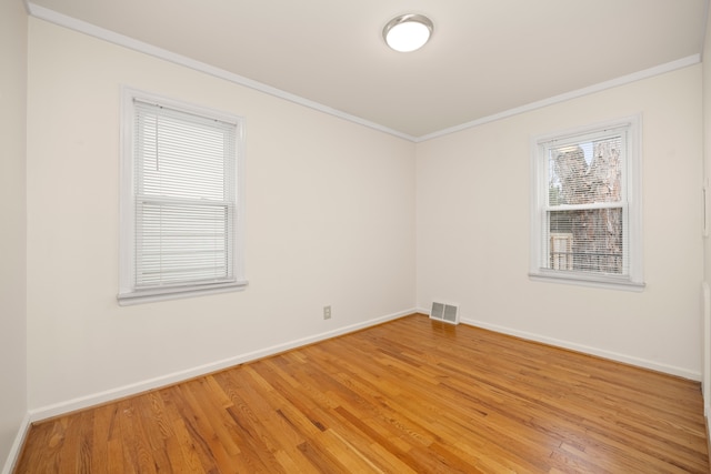 unfurnished room featuring hardwood / wood-style flooring and crown molding