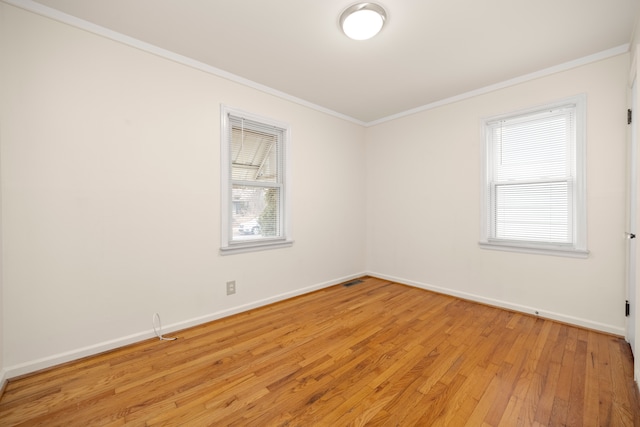 empty room featuring crown molding and light hardwood / wood-style flooring