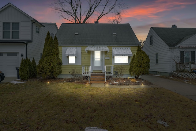 view of front of property with a garage and a lawn