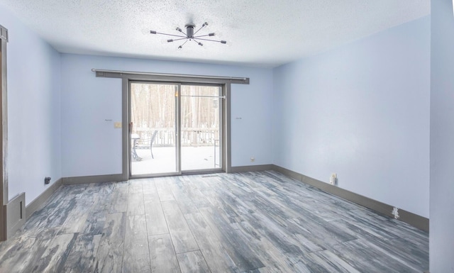 spare room with hardwood / wood-style flooring and a textured ceiling