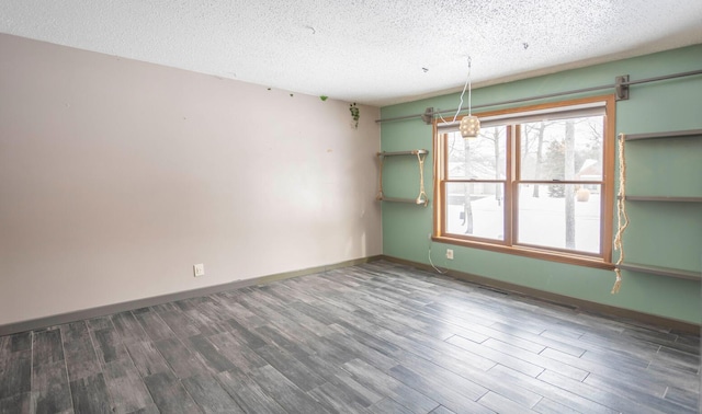 empty room featuring dark hardwood / wood-style flooring and a textured ceiling