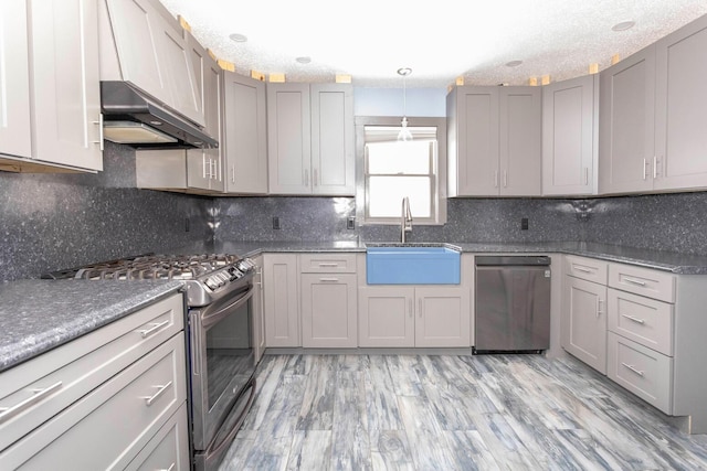 kitchen featuring sink, backsplash, gray cabinetry, and stainless steel appliances