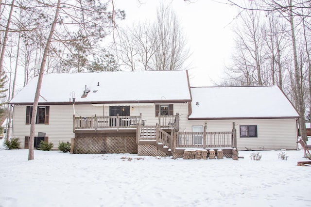 snow covered property with a wooden deck