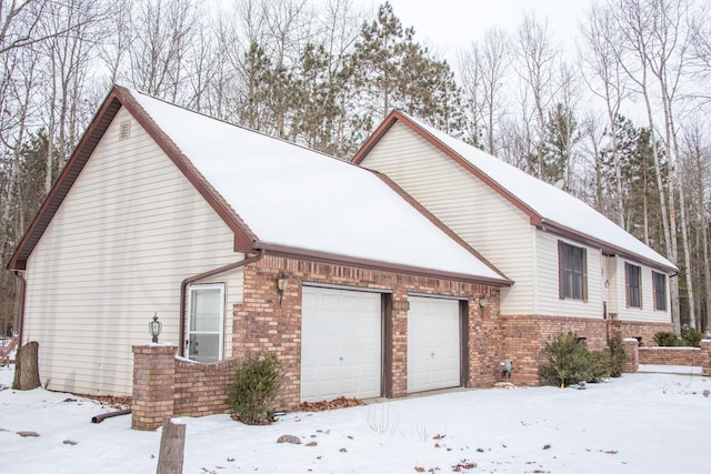 view of snow covered exterior featuring a garage