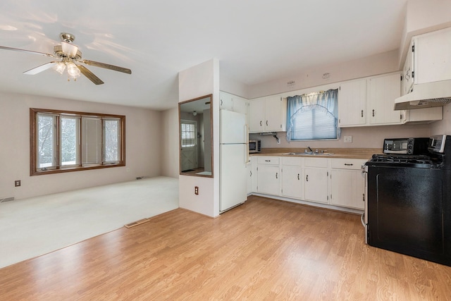 kitchen featuring white cabinetry, stainless steel appliances, washer / dryer, and light wood-type flooring