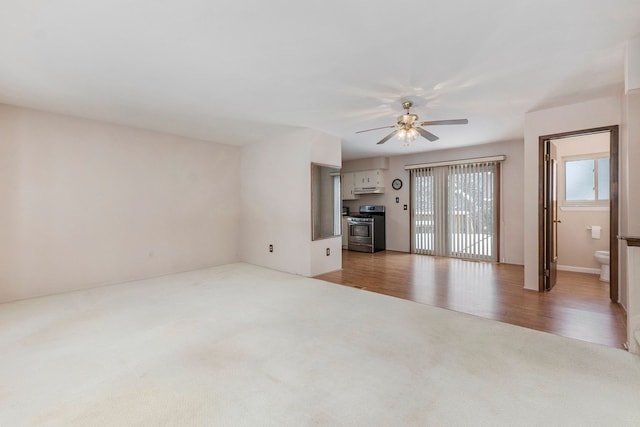 unfurnished living room featuring ceiling fan and carpet