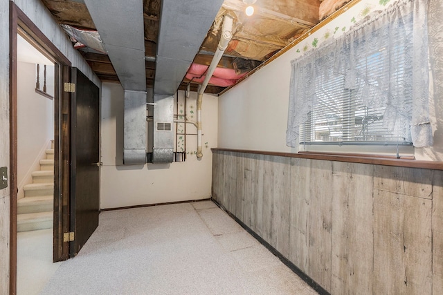 basement featuring wooden walls