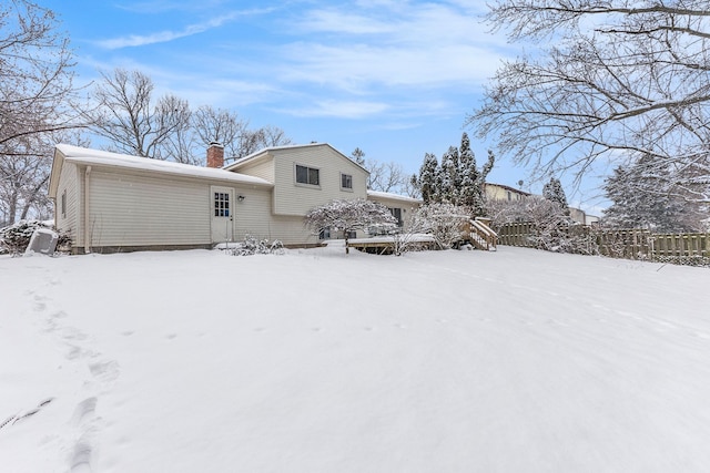 view of snow covered back of property