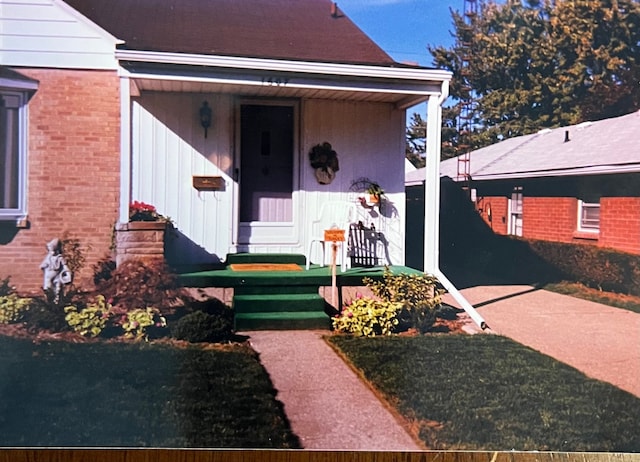 doorway to property featuring brick siding