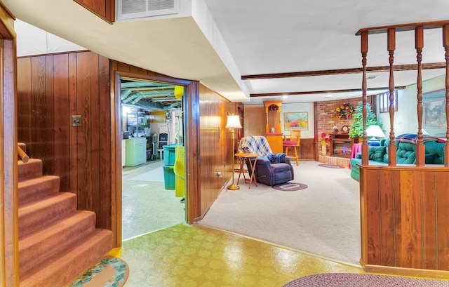 interior space with tile patterned floors, visible vents, wood walls, and stairs