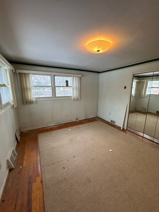 empty room with plenty of natural light and wood-type flooring