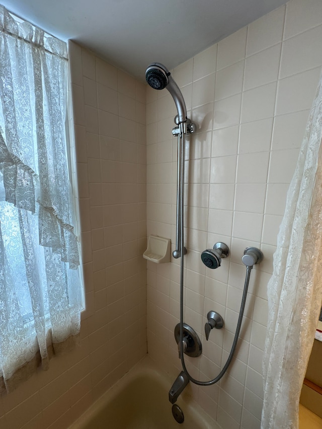 interior details featuring shower / bathtub combination with curtain