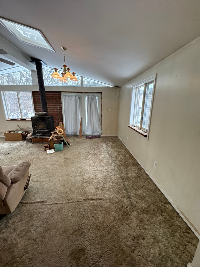 unfurnished living room with lofted ceiling, carpet floors, and a wood stove