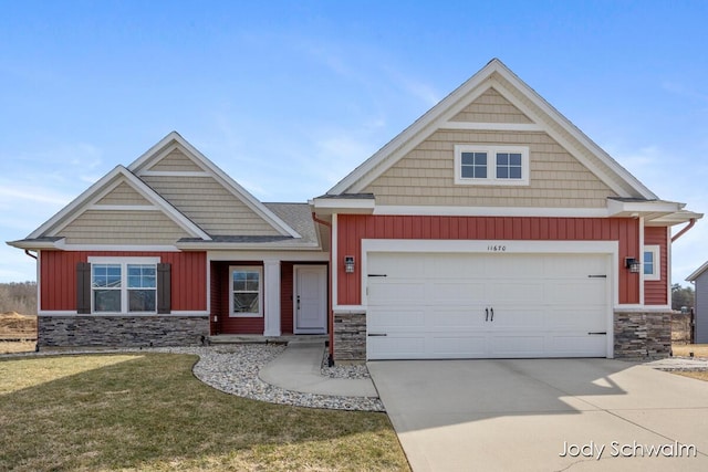 craftsman-style house with driveway, stone siding, board and batten siding, an attached garage, and a front yard