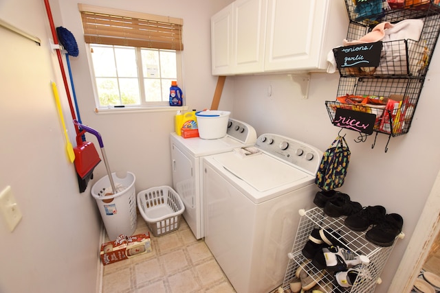 washroom with washer and dryer and cabinets