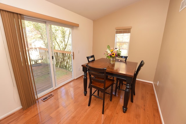 dining area with lofted ceiling and light hardwood / wood-style flooring