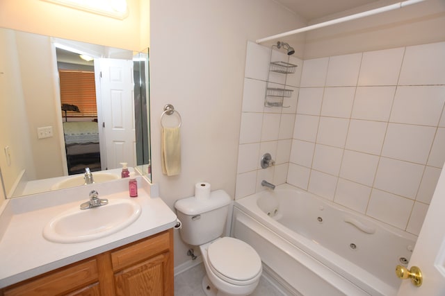 full bathroom with tiled shower / bath, vanity, and toilet