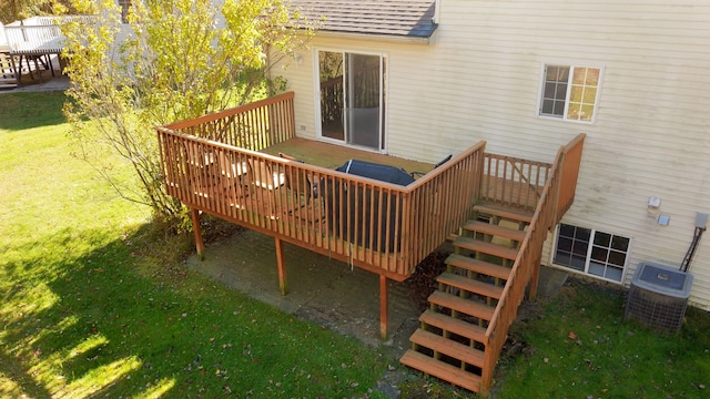 wooden terrace with central AC unit and a yard