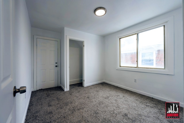 unfurnished bedroom with dark carpet