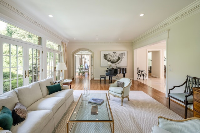 living room with crown molding, french doors, and light wood-type flooring