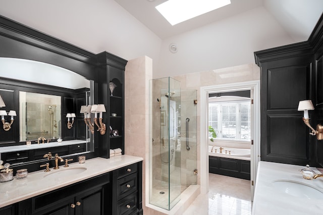 bathroom featuring independent shower and bath, vanity, lofted ceiling with skylight, and tile patterned floors