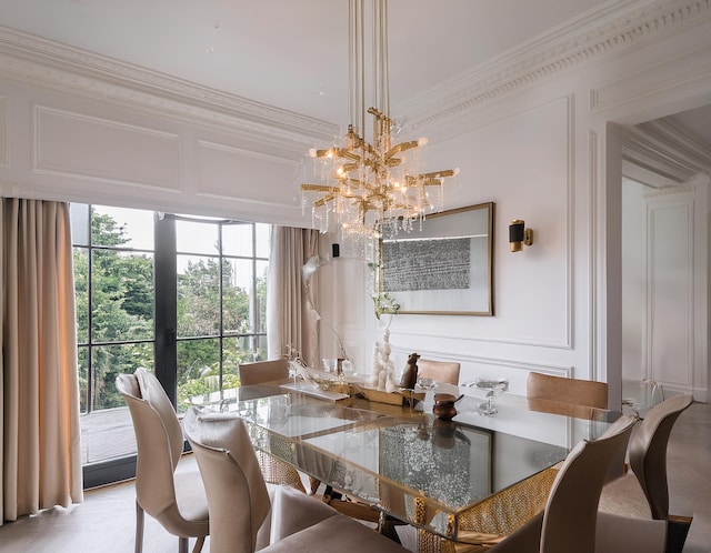 dining area featuring crown molding and a notable chandelier