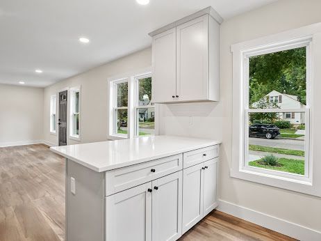 kitchen with white cabinetry, light hardwood / wood-style flooring, and kitchen peninsula