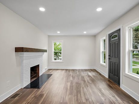 unfurnished living room with dark wood-type flooring and plenty of natural light