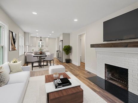 living room with wood-type flooring and a brick fireplace