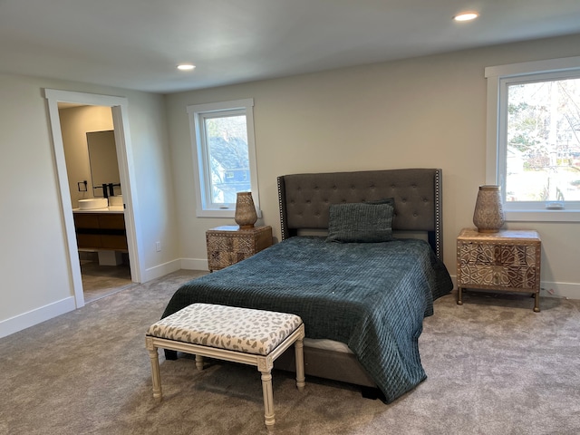 bedroom featuring multiple windows, connected bathroom, and carpet