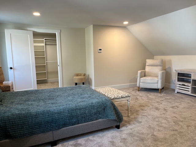 bedroom with lofted ceiling, carpet flooring, and a spacious closet