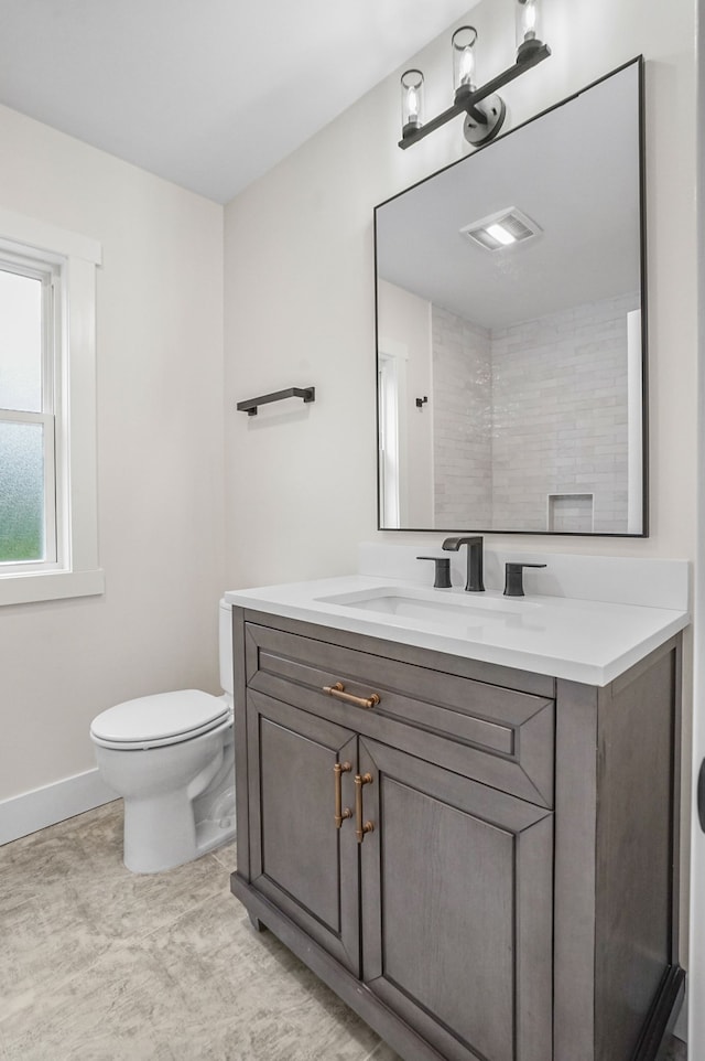 bathroom featuring vanity, toilet, and walk in shower