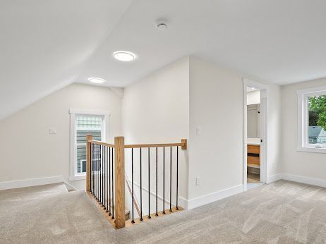 bonus room featuring lofted ceiling and light carpet