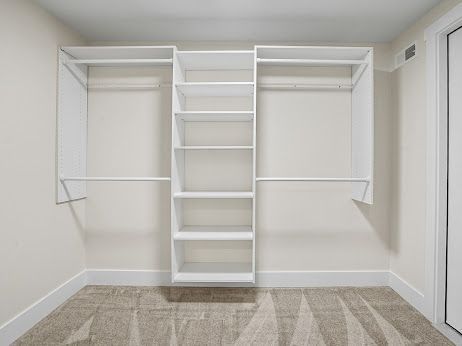 walk in closet featuring light carpet