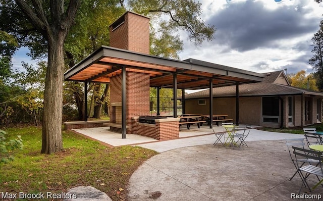 view of patio with a fireplace and exterior kitchen