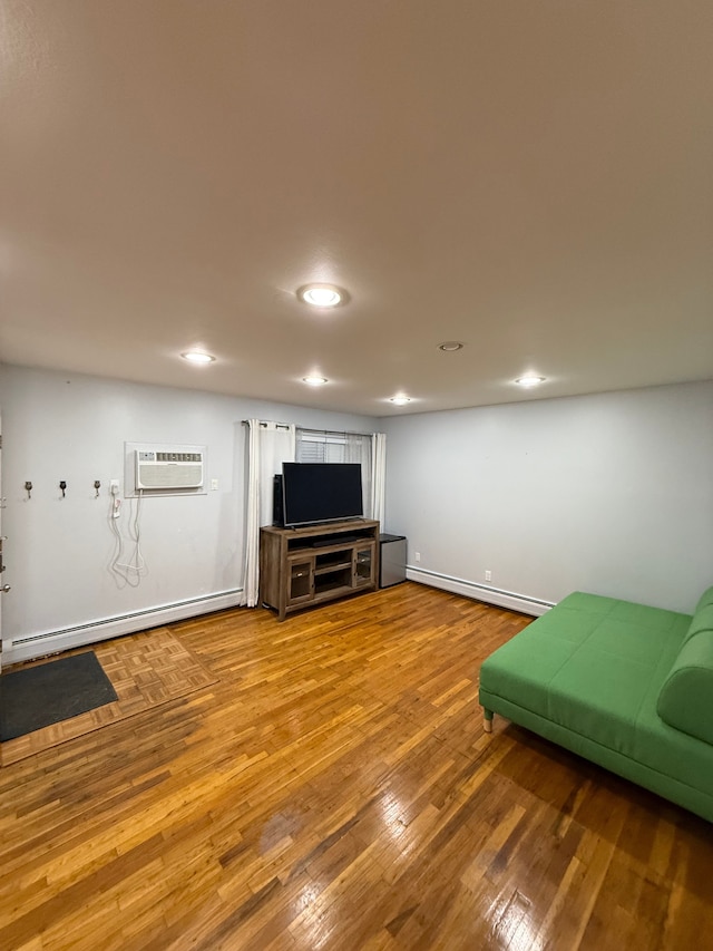 living room with hardwood / wood-style floors, a baseboard heating unit, and a wall mounted AC