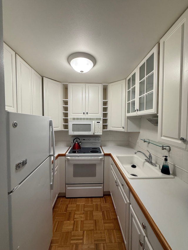 kitchen featuring sink, white appliances, backsplash, white cabinets, and parquet floors