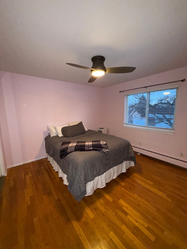 bedroom with ceiling fan, dark hardwood / wood-style floors, and a baseboard radiator