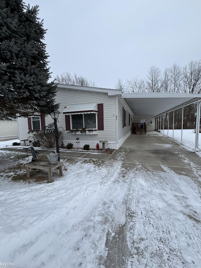 snow covered property with a carport