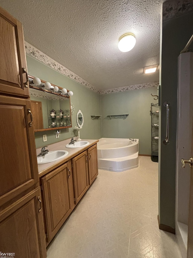 bathroom featuring a textured ceiling, vanity, and a bathing tub