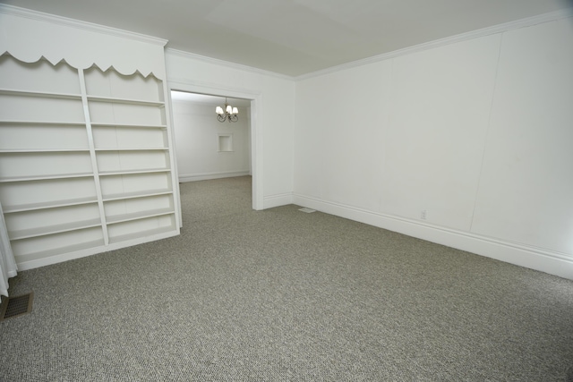 carpeted spare room featuring crown molding, built in shelves, and a chandelier