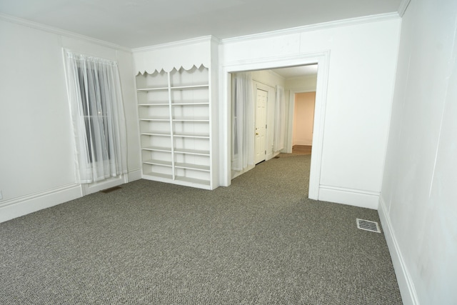 carpeted spare room with crown molding and built in features