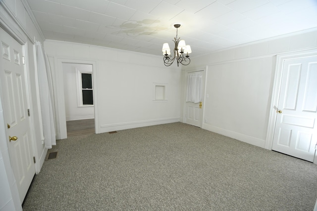 unfurnished room with ornamental molding, a chandelier, and carpet