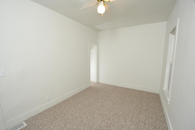 empty room featuring ceiling fan and carpet