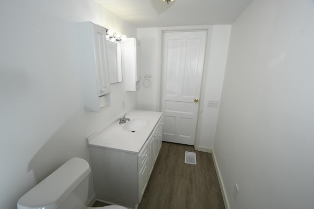 bathroom featuring vanity, hardwood / wood-style floors, and toilet