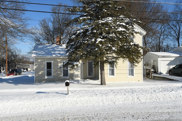 view of property hidden behind natural elements with an outbuilding and a garage