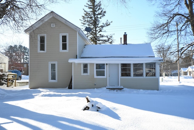 view of snow covered back of property